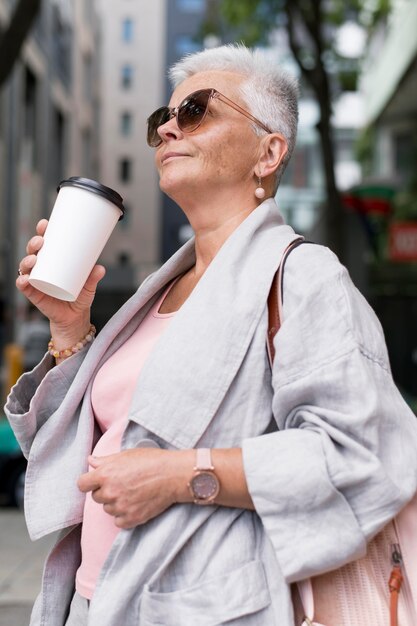 Donna del colpo medio che tiene la tazza di caffè