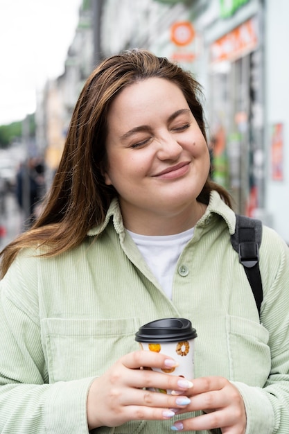 Medium shot woman holding coffee cup