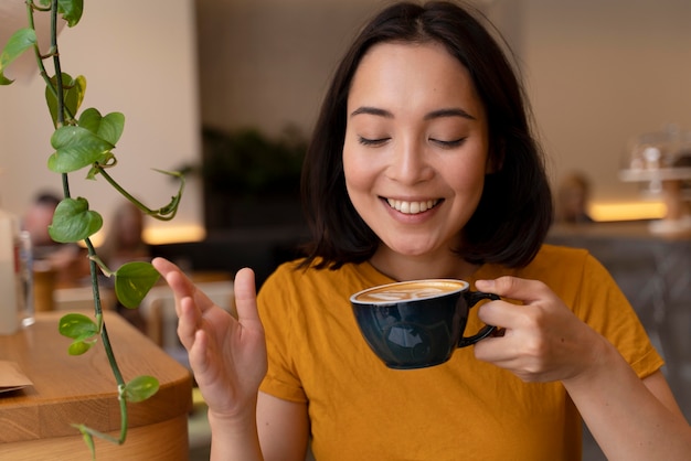 Donna del colpo medio che tiene la tazza di caffè