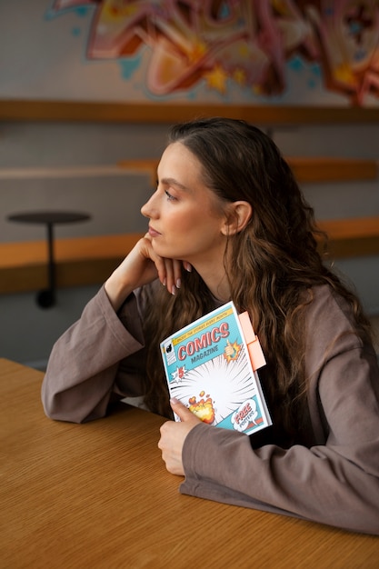 Free photo medium shot woman holding comics