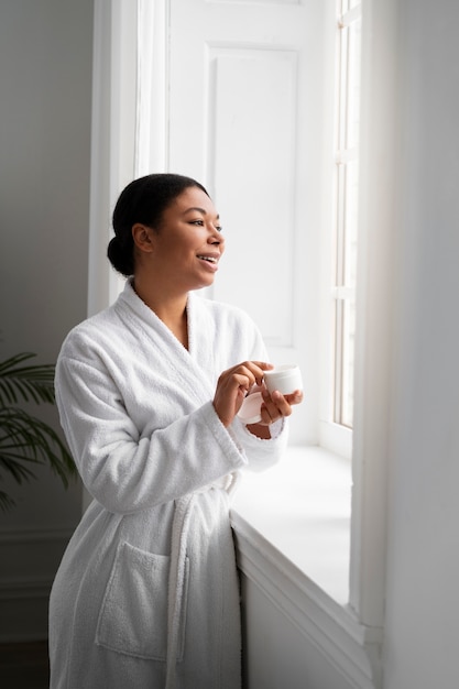 Medium shot woman holding cream container