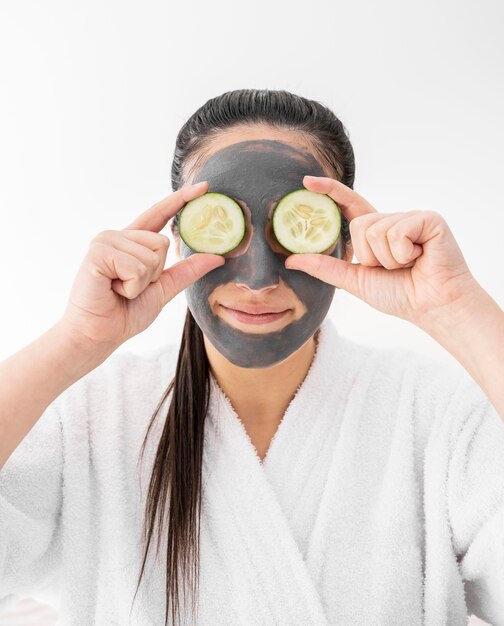 Medium shot woman holding cucumber slices