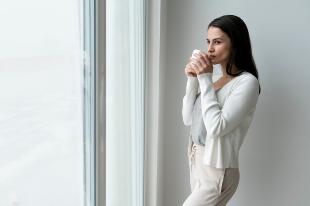 Medium shot woman holding cup