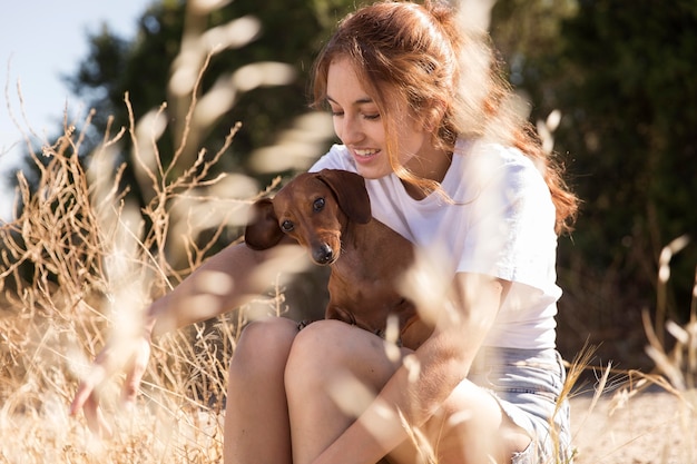 かわいい犬を抱いたミディアムショットの女性