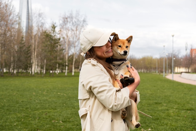 かわいい犬を抱いたミディアムショットの女性