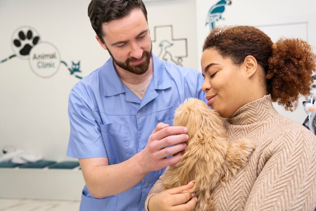 かわいい子犬を保持しているミディアムショットの女性