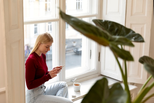 Free photo medium shot woman holding device