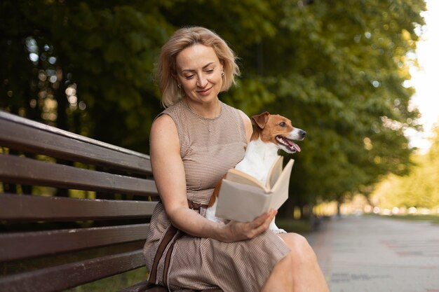 公園で犬を保持しているミディアムショットの女性