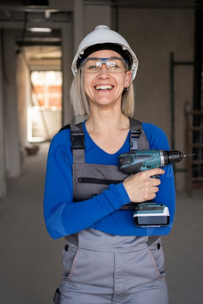 Foto gratuita trapano della tenuta della donna del colpo medio