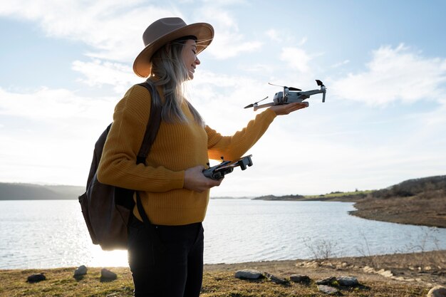 Medium shot woman holding drone outdoors