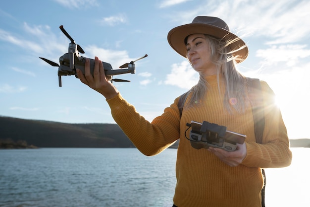 Free photo medium shot woman holding drone and remote