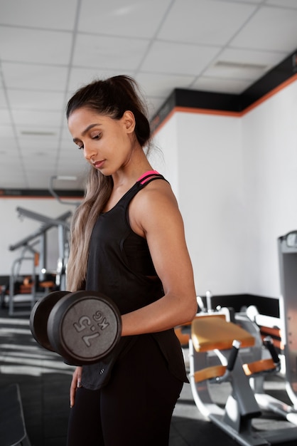 Free photo medium shot woman holding dumbbell