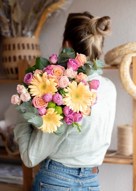 Средний снимок женщины, держащей букет цветов