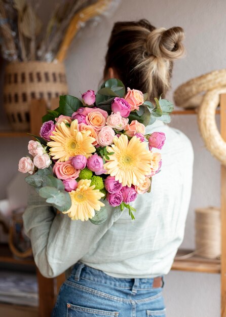 花の花束を保持しているミディアムショットの女性