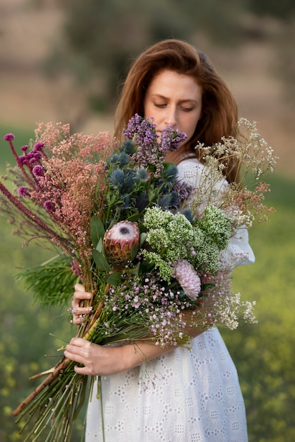 꽃 꽃다발을 들고 중간 샷 여성