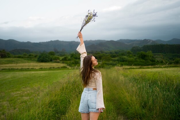 花を保持しているミディアムショットの女性