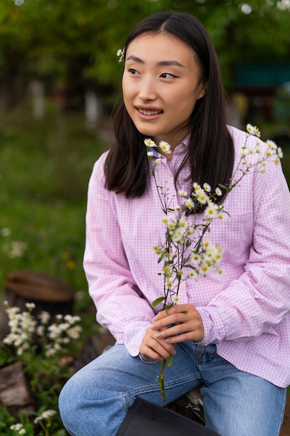 無料写真 花を保持しているミディアムショットの女性