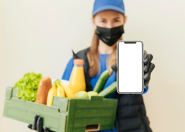 Free photo medium shot woman holding food crate