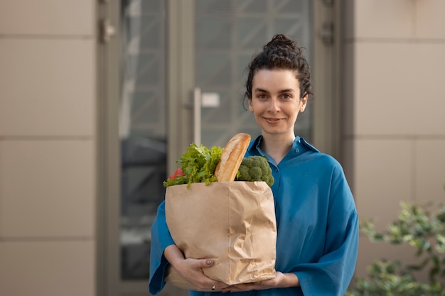 Medium shot woman holding groceries