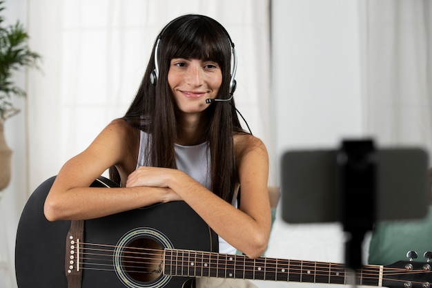 Medium shot woman holding guitar