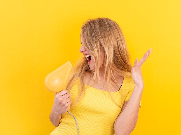 Medium shot woman holding hair dryer