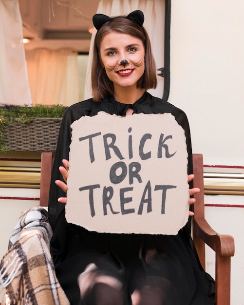 Free photo medium shot woman holding halloween sign