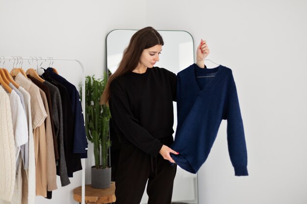 Medium shot woman holding hanger