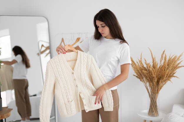 Medium shot woman holding hanger