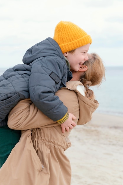 幸せな男の子を保持しているミディアムショットの女性