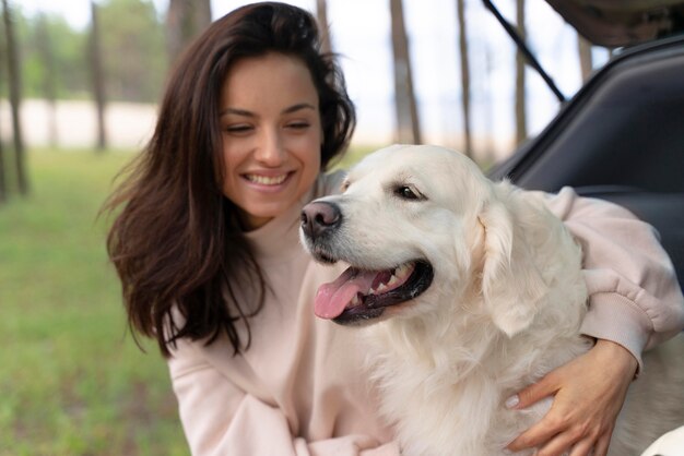 幸せな犬を保持しているミディアムショットの女性