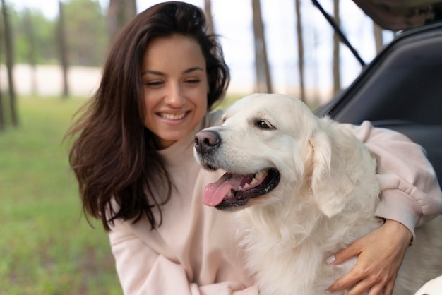 Medium shot woman holding happy dog