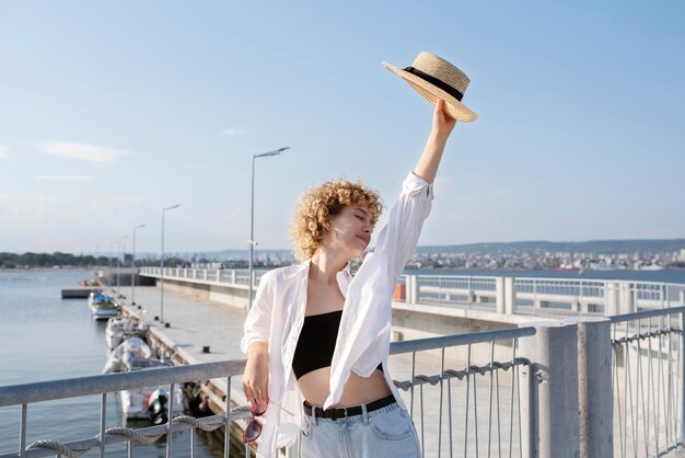 Medium shot woman holding hat
