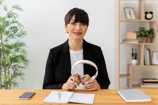 Free photo medium shot woman holding headphones