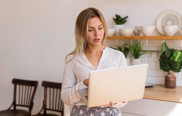 Medium shot woman holding her laptop