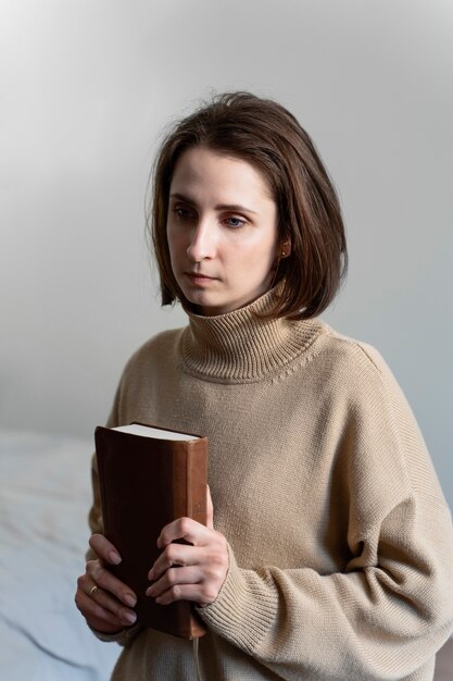 聖書を持っているミディアムショットの女性