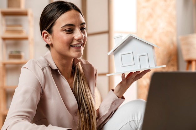 Medium shot woman holding house