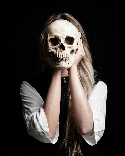 medium shot of woman holding human skull