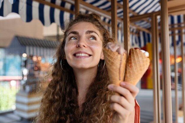 Medium shot woman holding ice cream cones