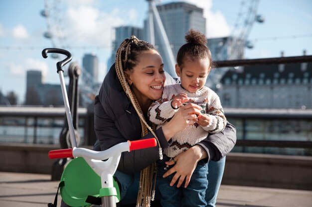 Medium shot woman holding kid outdoors