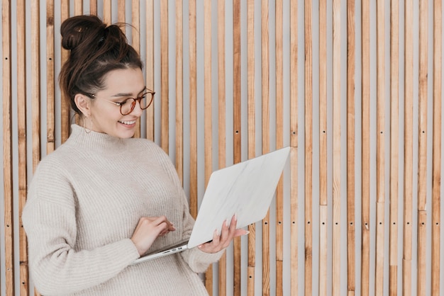 Medium shot woman holding laptop