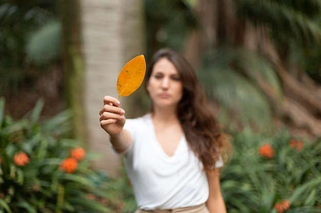 Free photo medium shot woman holding leaf