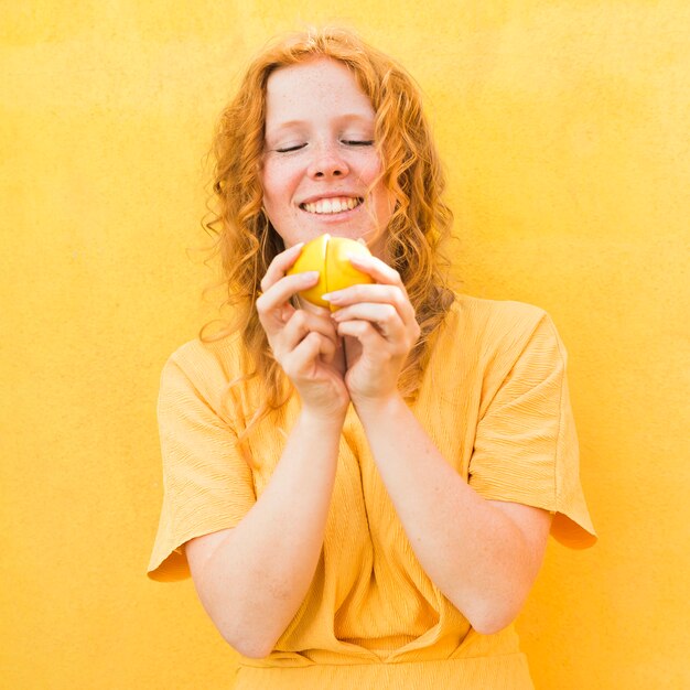Medium shot woman holding lemon
