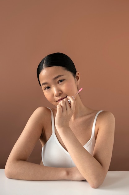 Medium shot woman holding lipgloss