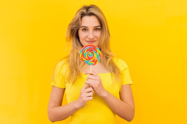 Medium shot woman holding lollipop