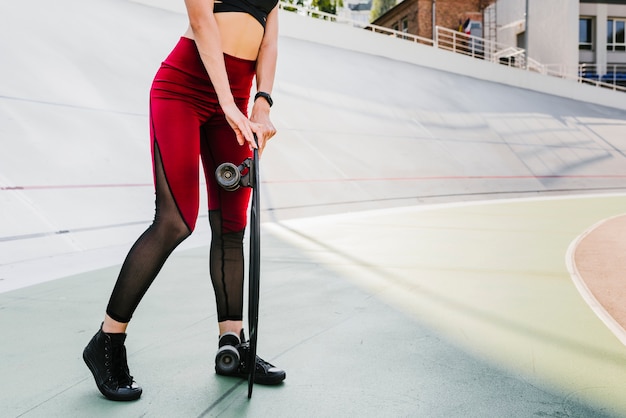 Medium shot of woman holding a longboard