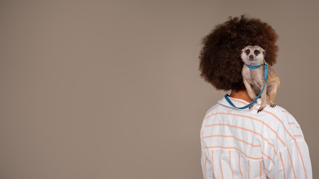 Free photo medium shot woman holding meerkat