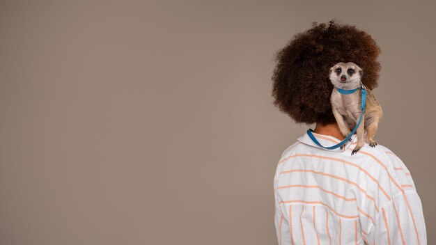 Medium shot woman holding meerkat