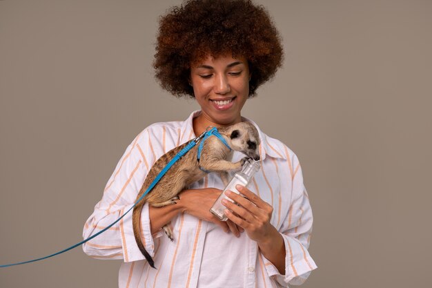 Medium shot woman holding meerkat