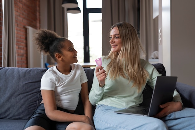 Foto gratuita donna del colpo medio che tiene la tazza mestruale