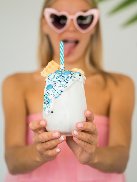 Free photo medium shot woman holding milkshake